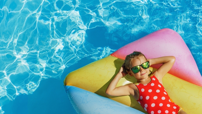 kind auf Luftmadrazte im Pool