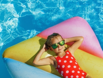 Kind auf Luftmatraze im Pool
